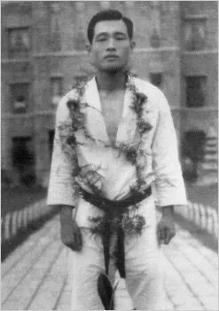 Kwon Jae-Hwa im Dobok mit Blumenkranz um den Hals vor einem Gebäude
