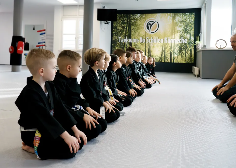Panda-Kids-Gruppe der Taekwon-Do Schulen Könnecke sitzt konzentriert in einer Reihe und hört der Trainerin zu