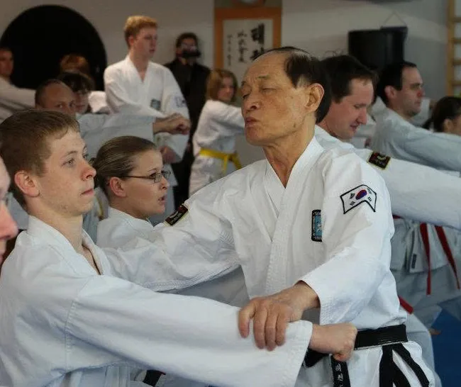 Großmeister Kwon Jae-Hwa korrigiert bei einem Lehrgang in Traunstein 2012 persönlich die Technik von Sergej Neumüller